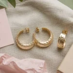 Boucle d oreilles tendance 2025 : créoles martelées et mono-boucle sur lin taupe